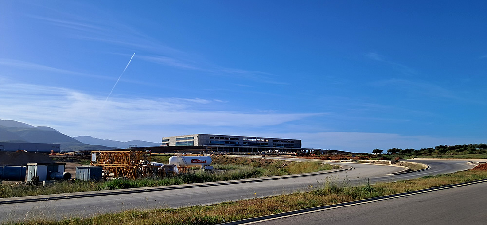 Access road and terminal building at the new Kastelli Airport construction site in May 2026